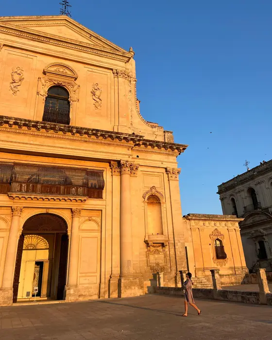 A baroque church facade glowing gold at sunset in Noto, Sicily
